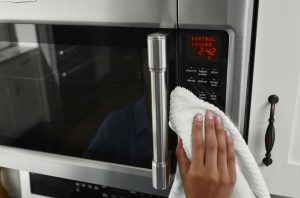 Image of a person cleaning a microwave