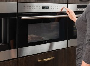 Image of a person pressing a button on a microwave