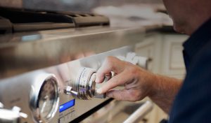 Image of a man turning an oven control knob